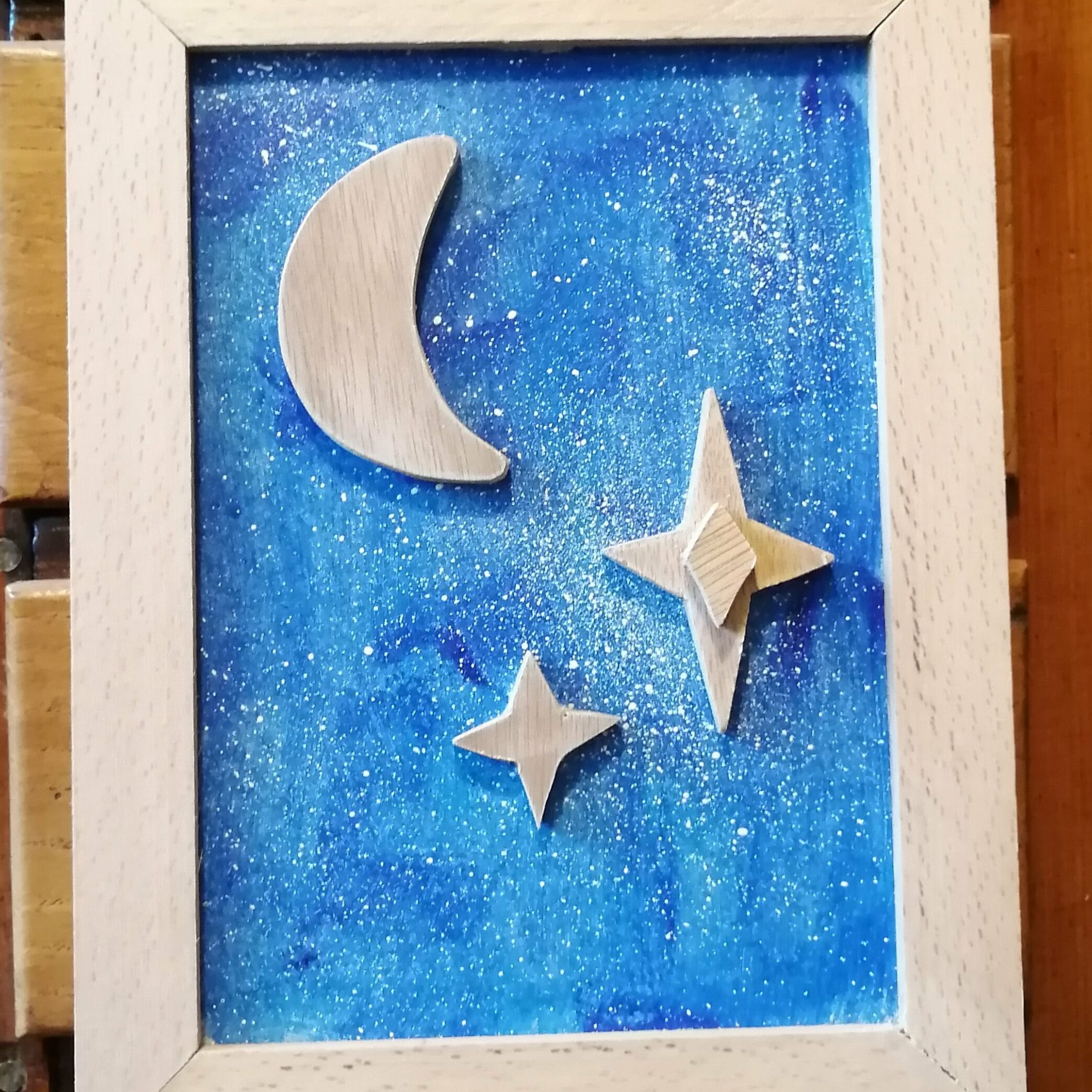 tableau en bois avec des reliefs en forme d'étoiles et un fond bleu