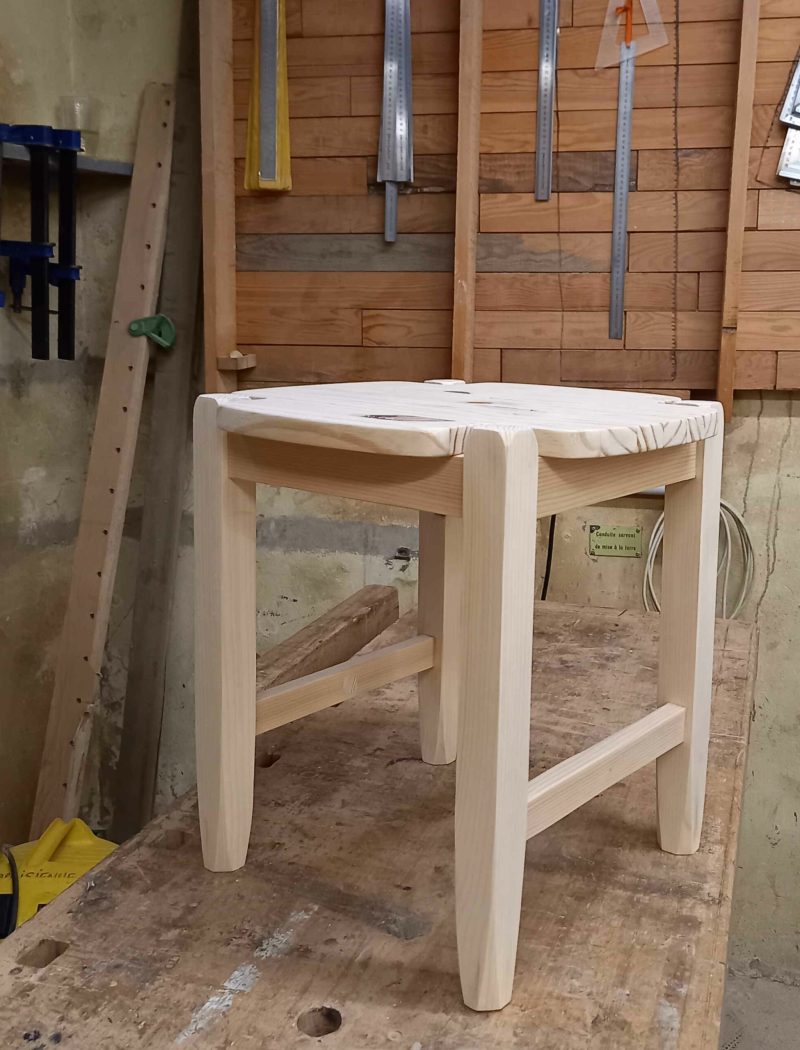 tabouret en bois posé sur un établi en bois