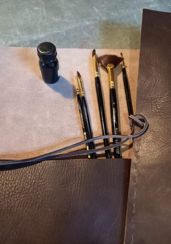 housse en cuir avec des pinceaux à côté