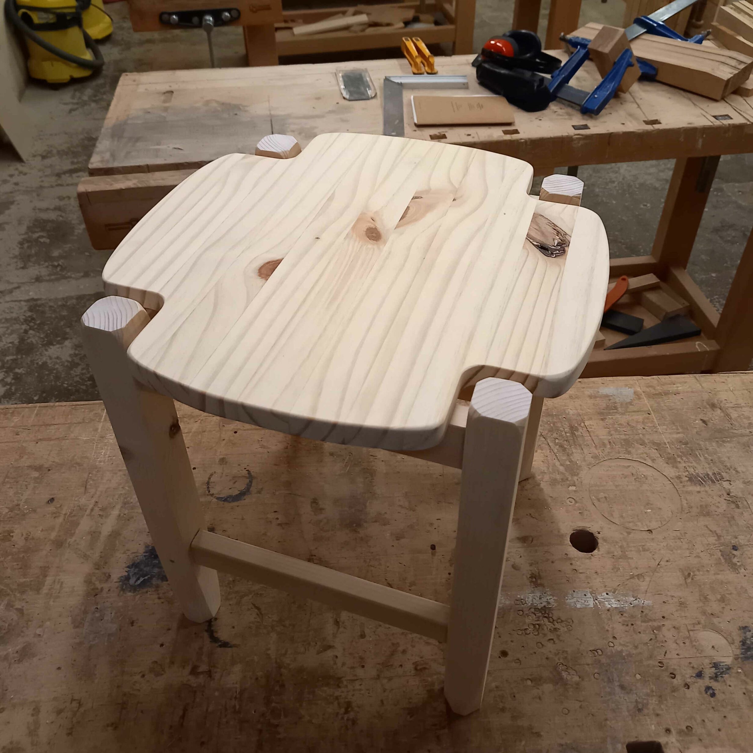 tabouret en bois posé sur un établi en bois