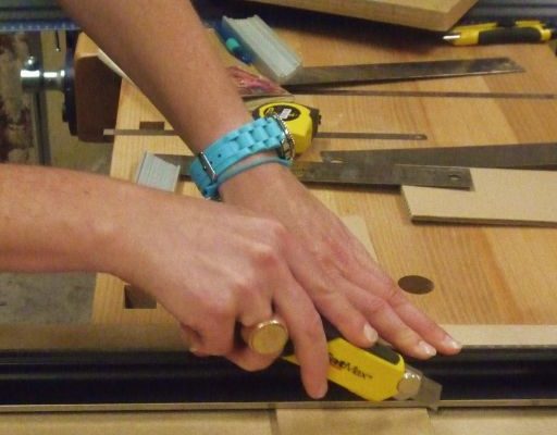 quelqu'un en train de couper du carton avec un cutter