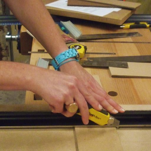 quelqu'un en train de couper du carton avec un cutter