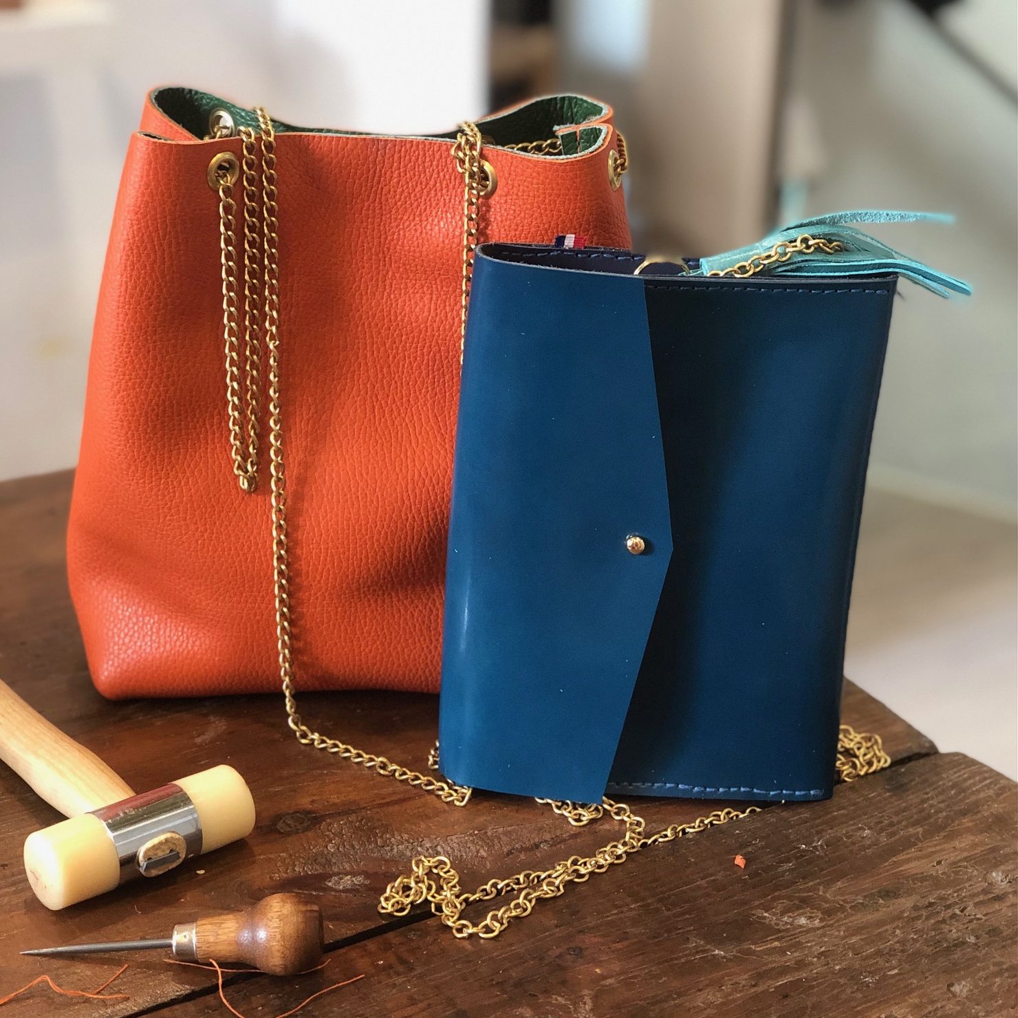 gros plan sur des sacs en cuir colorés posés sur une table en bois