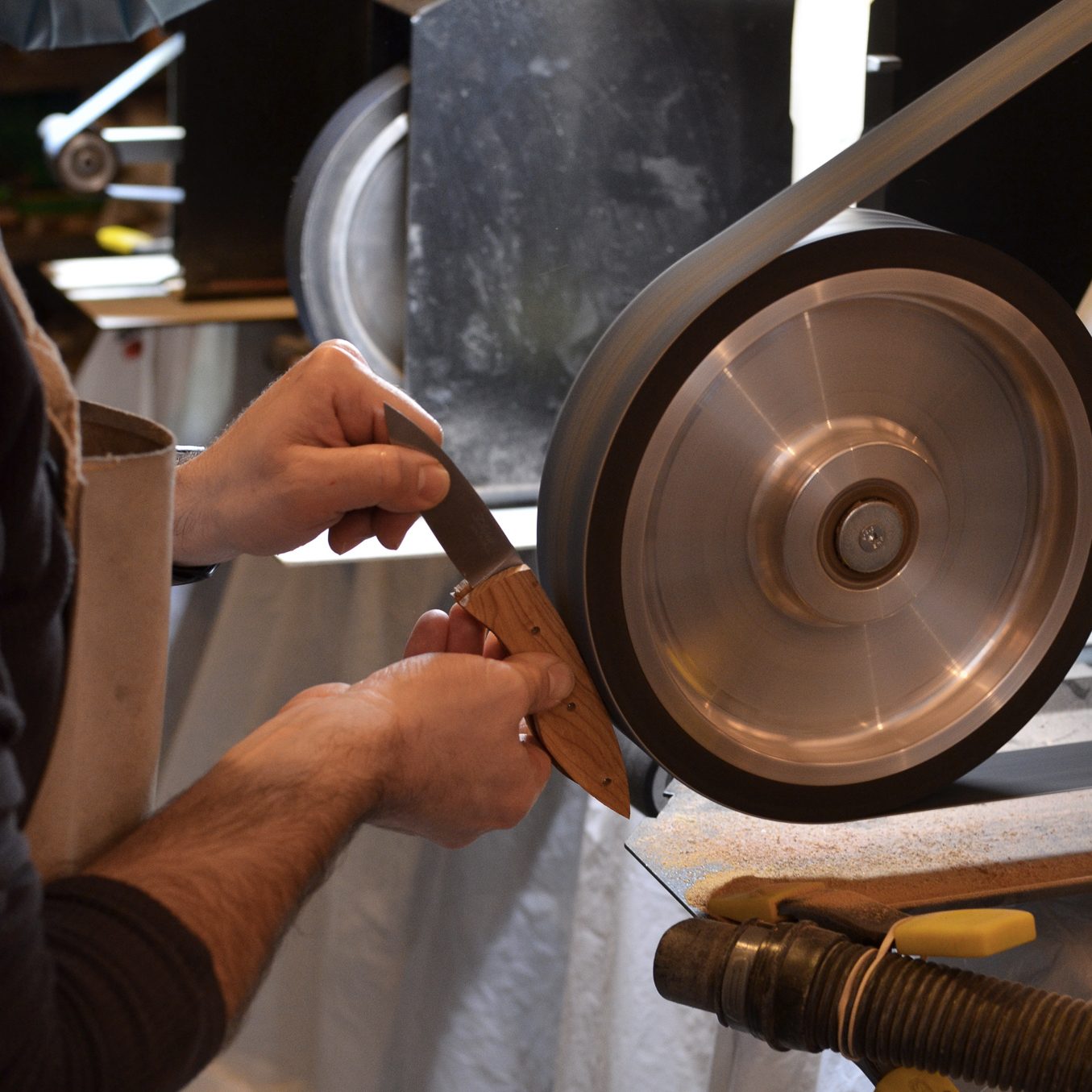 une personne en train de finir la création d'un couteau avec une machine